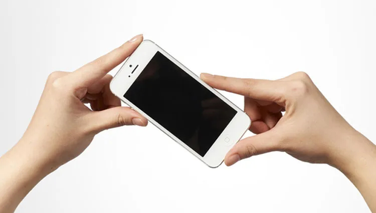 iPhoneを親指と人さし指で持つ手元